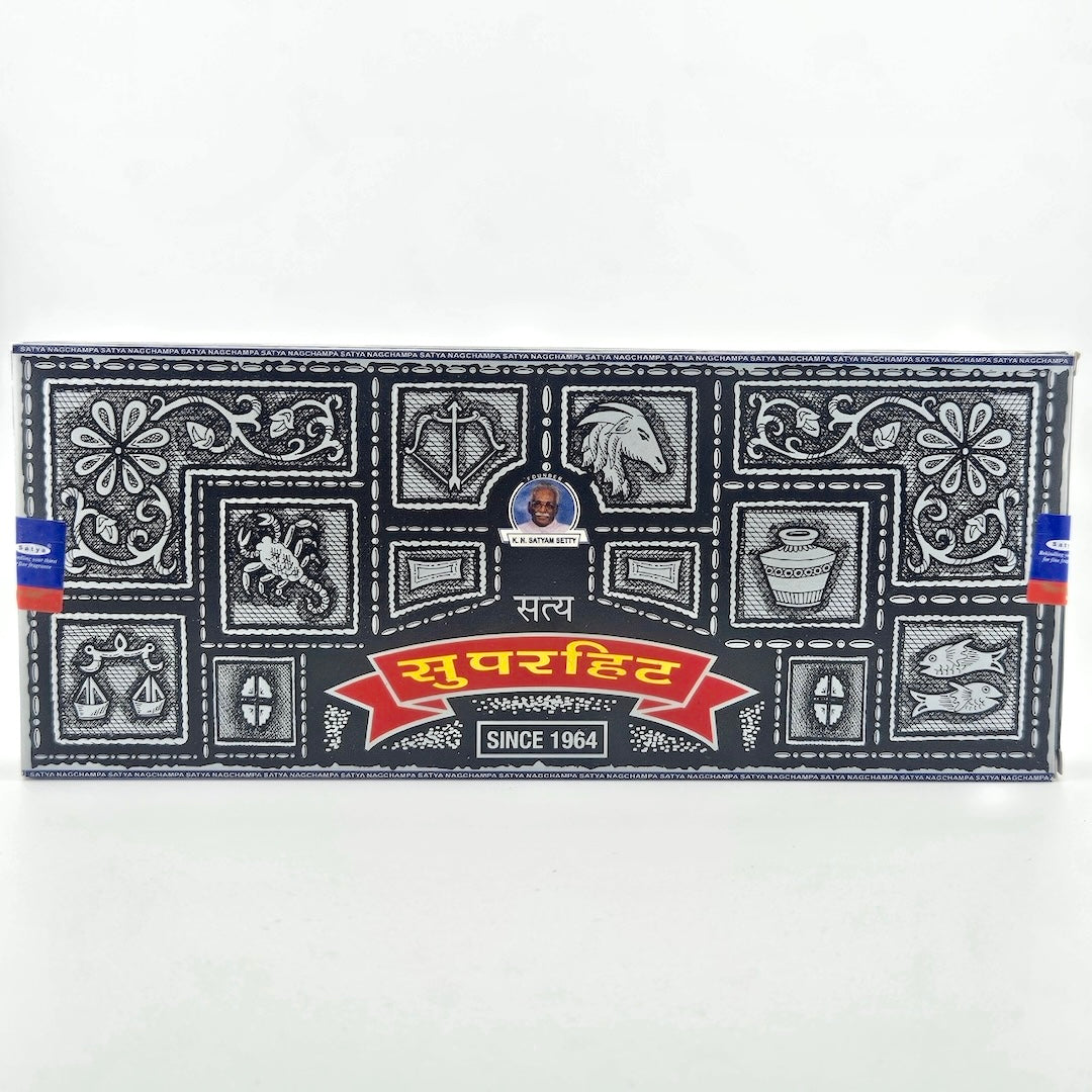 Black box with white tile motif with images of zodiac signs around red banner with scent name beneath company name.