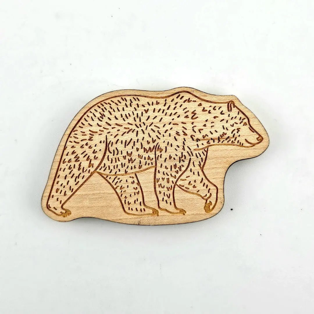 Wooden bear-shaped magnets on a white background