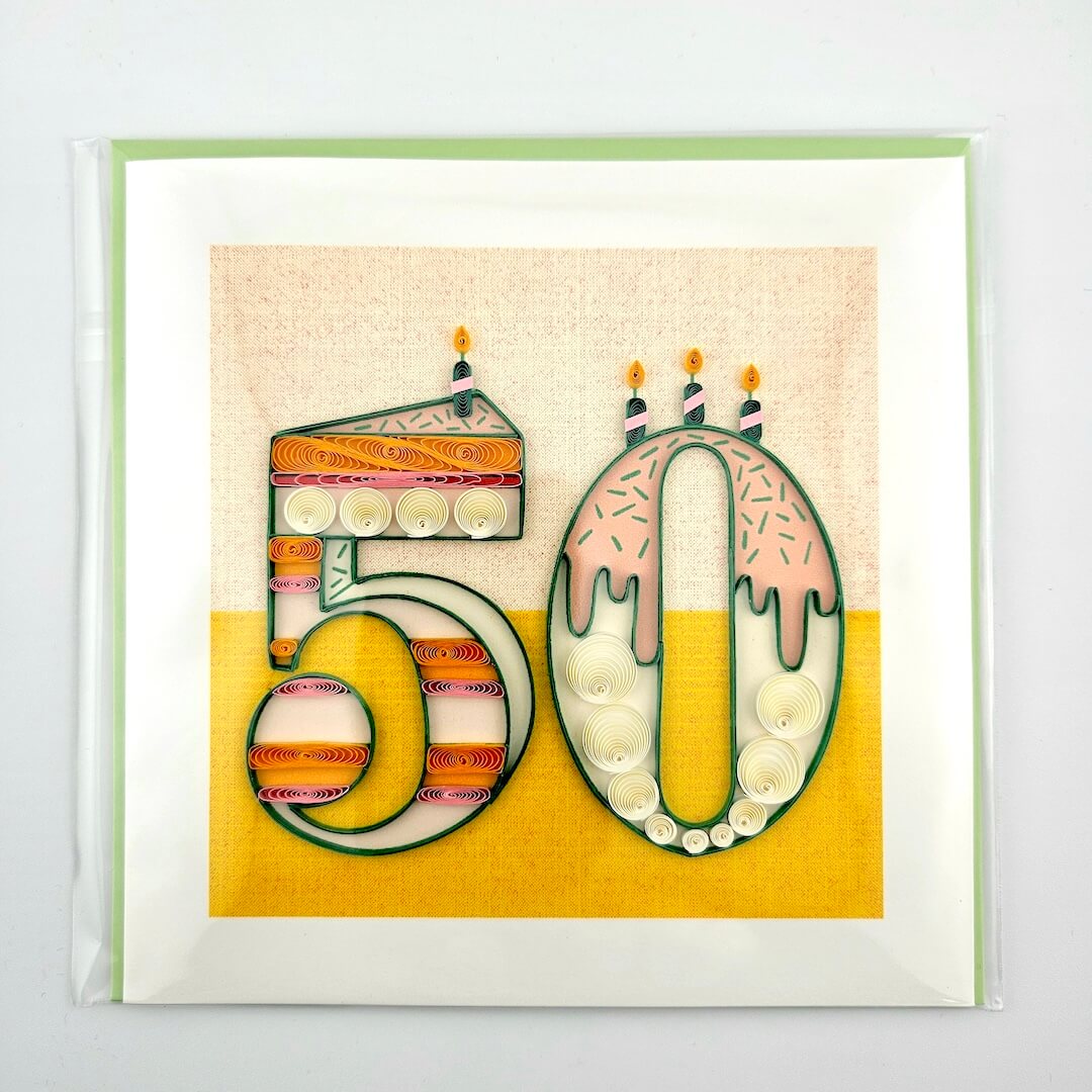 Framed artwork with decorative numbers '50' resembling birthday candles on a yellow background.