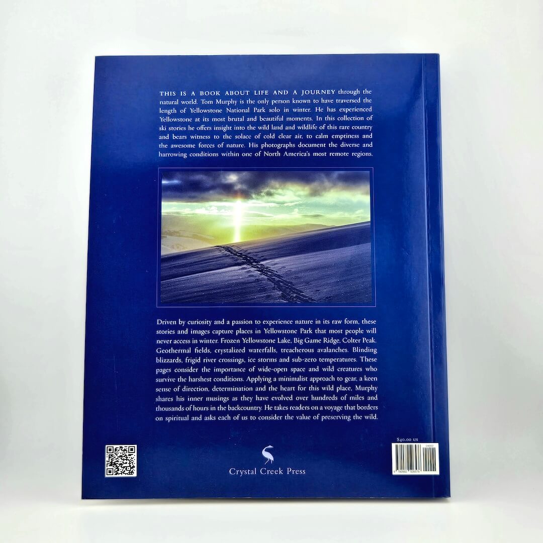 Back cover of a book with text and a scenic image on a white background