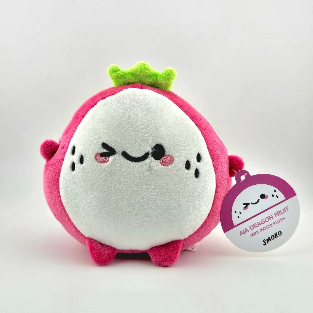 Plush dragon fruit toy with a tag on a white background