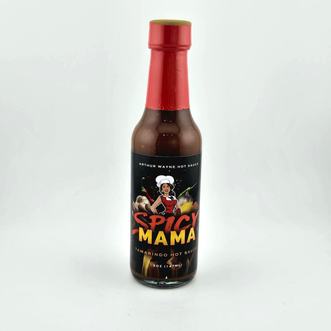 Glass bottle of hot sauce safety sealed with plastic. Label across main body of bottle details flavor and image depicting it.
