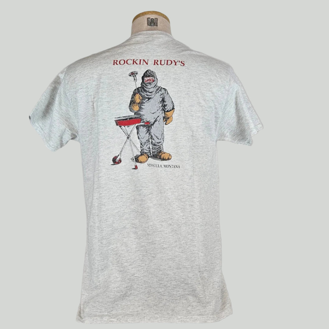 Heathered gray t-shirt with "ROCKIN RUDY'S" at top with man in hazmat suit grilling a record, city name at bottom.