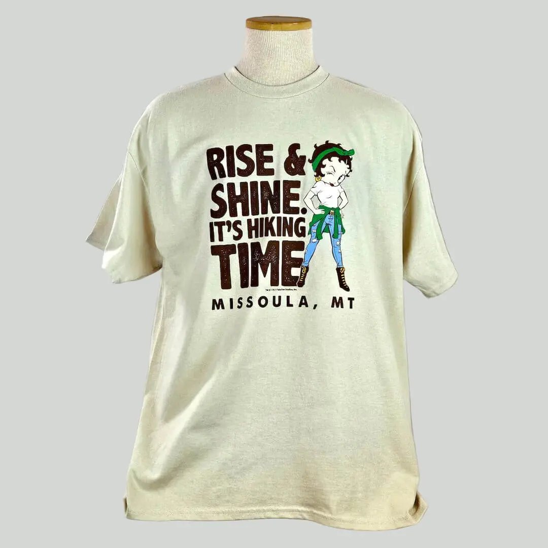 Beige t-shirt with graphic and text on a mannequin against a white background