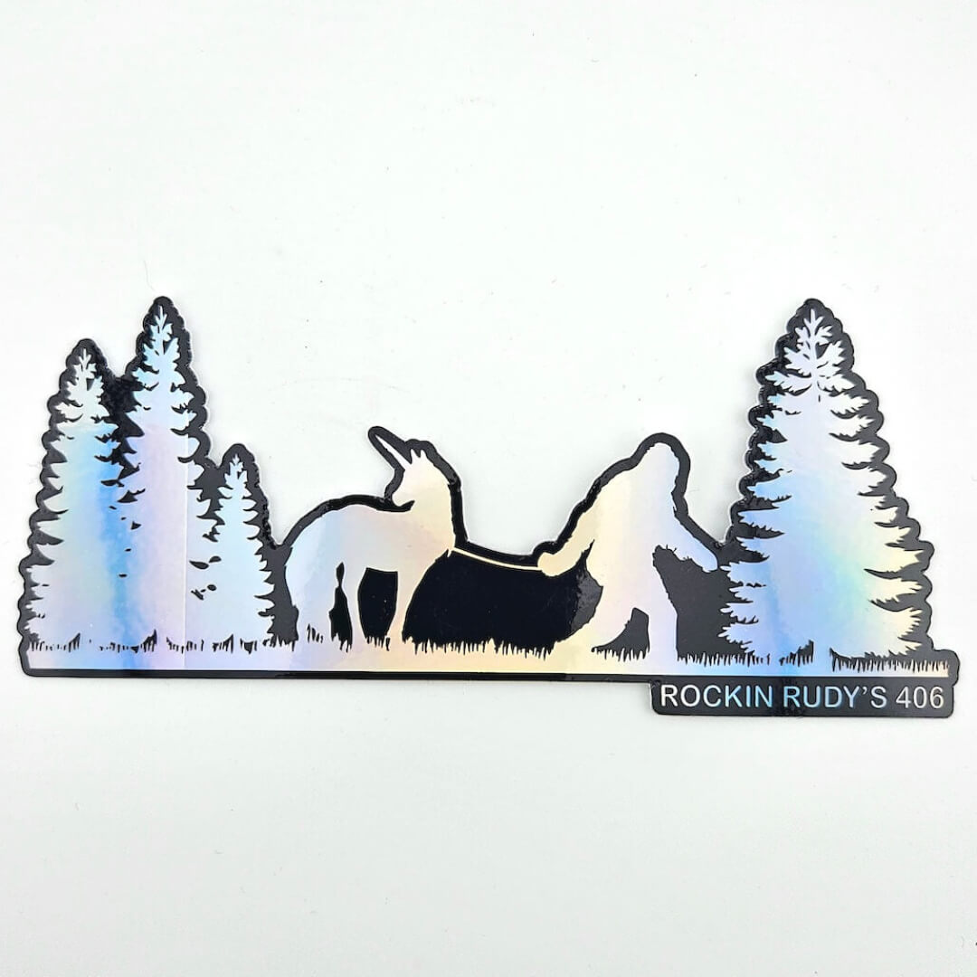 Metallic foil sticker of Bigfoot and unicorn in a forest with 'Rockin Rudy's 406' branding on a white background.