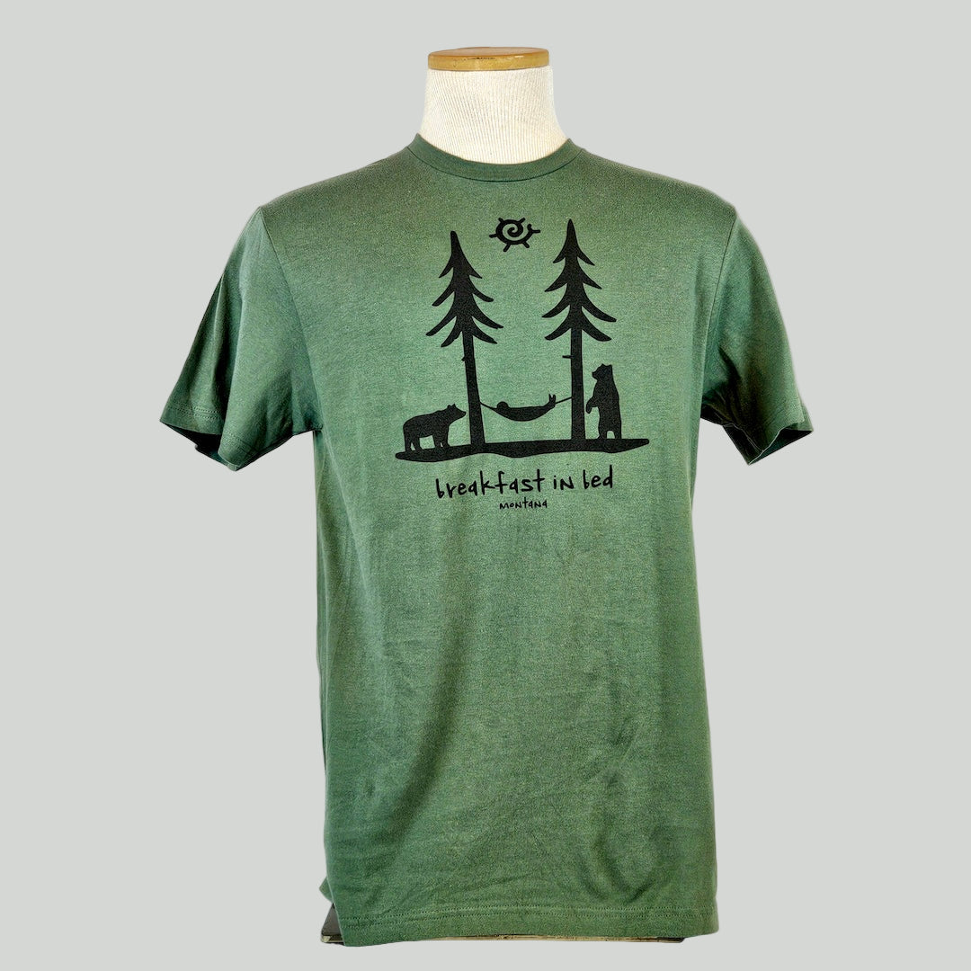 Green t-shirt with two trees and a hammock above text "breakfast in bed, Montana"