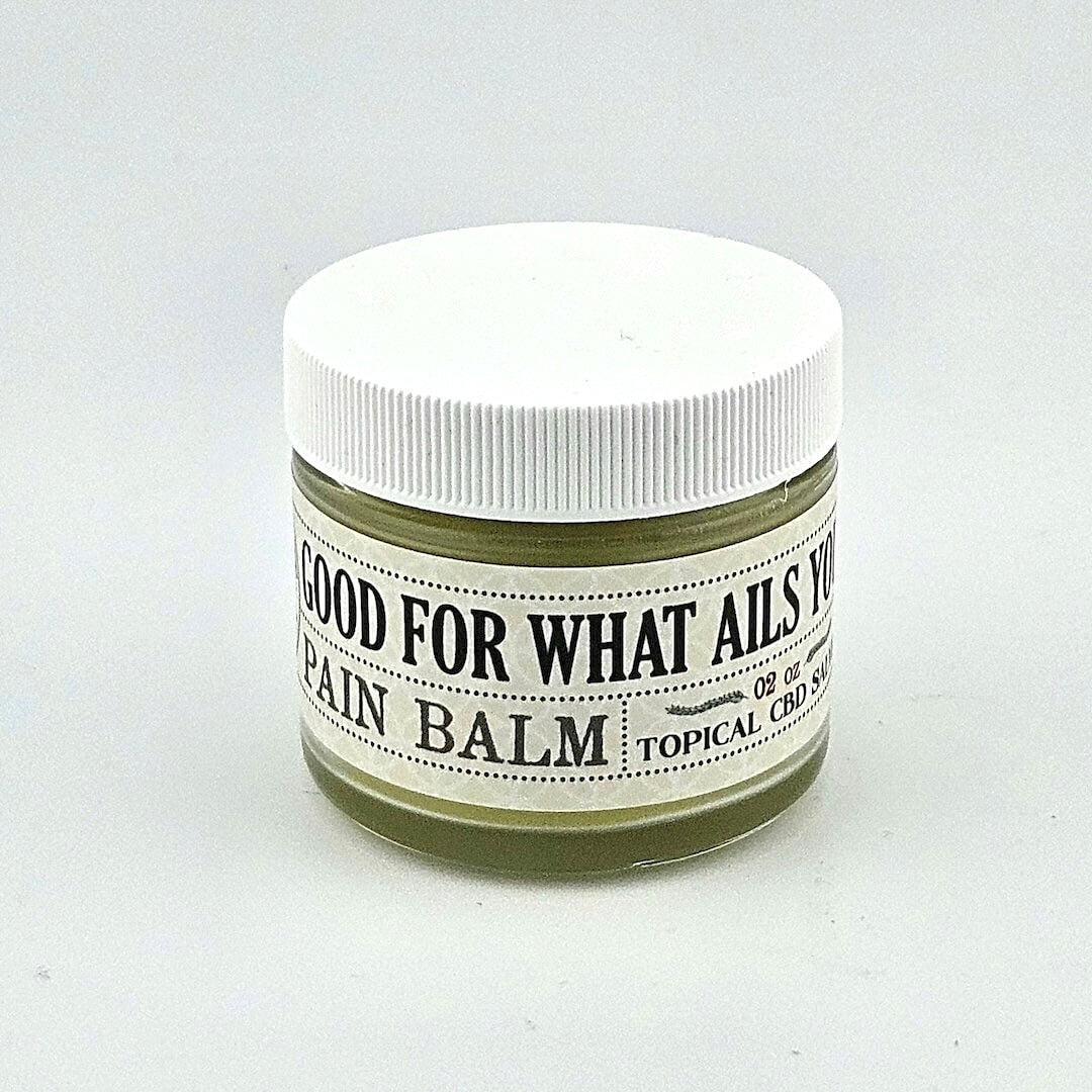 Short glass jar with white plastic lid and white label with black print.