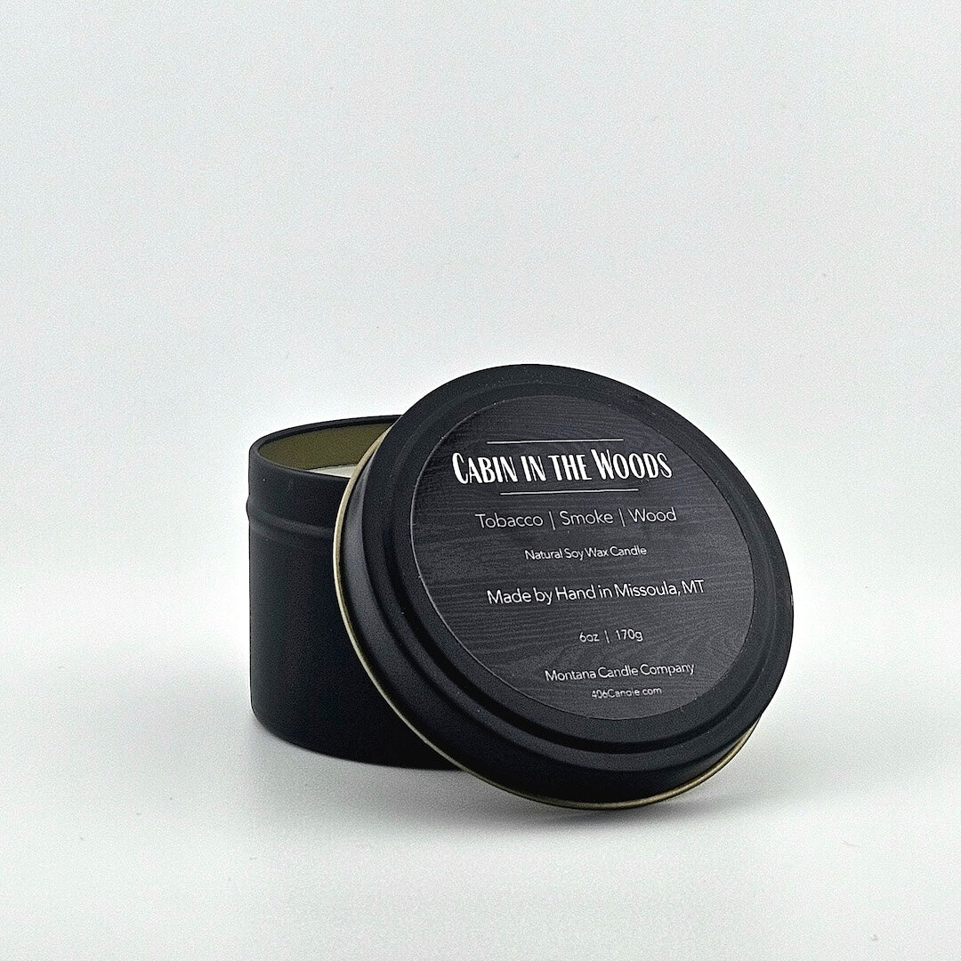 Black candle tin labeled with scent name, listed scent components, company & manufacturing information below.