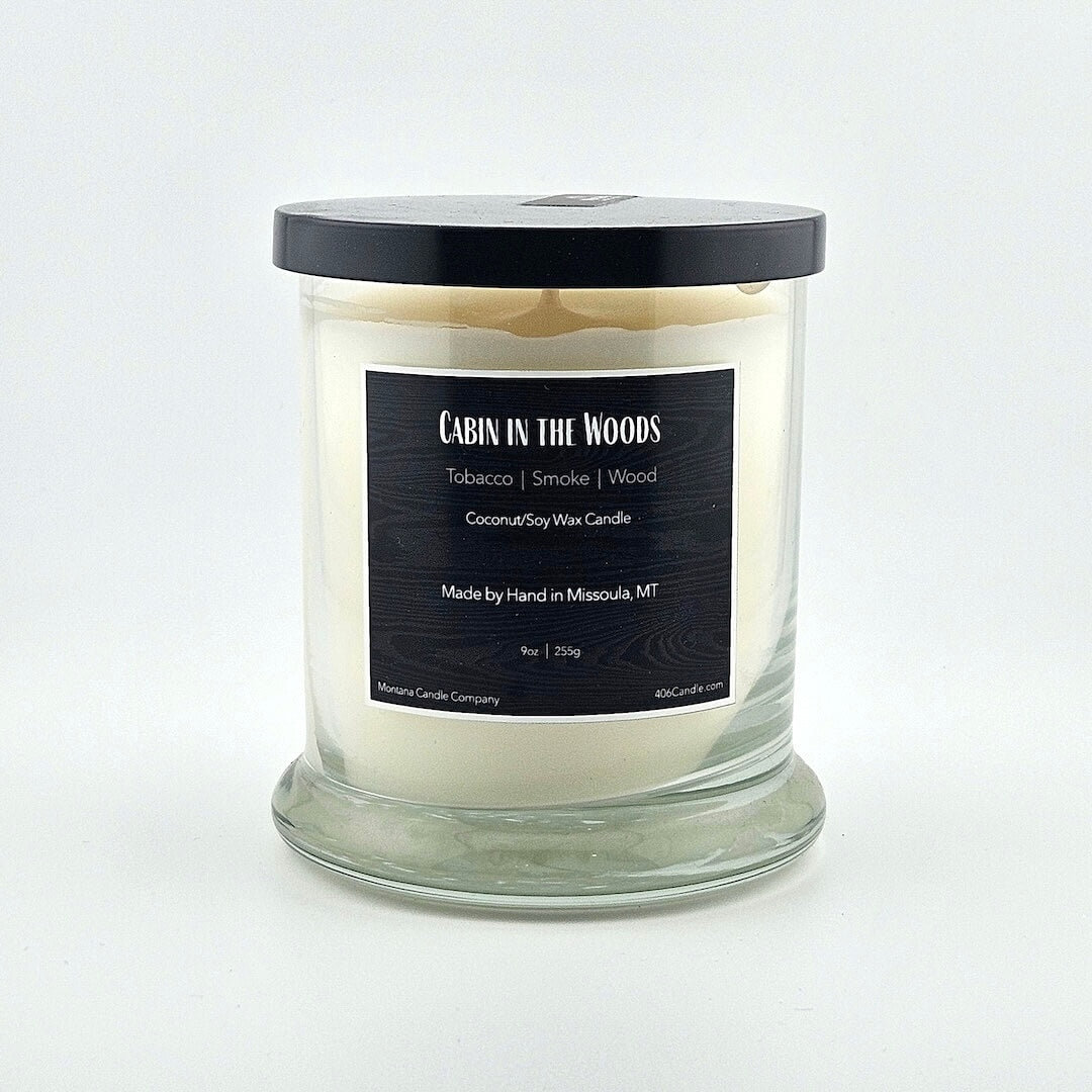 Glass jarred candle with black lid, label with printed scent name at top then listed scent components then more details below