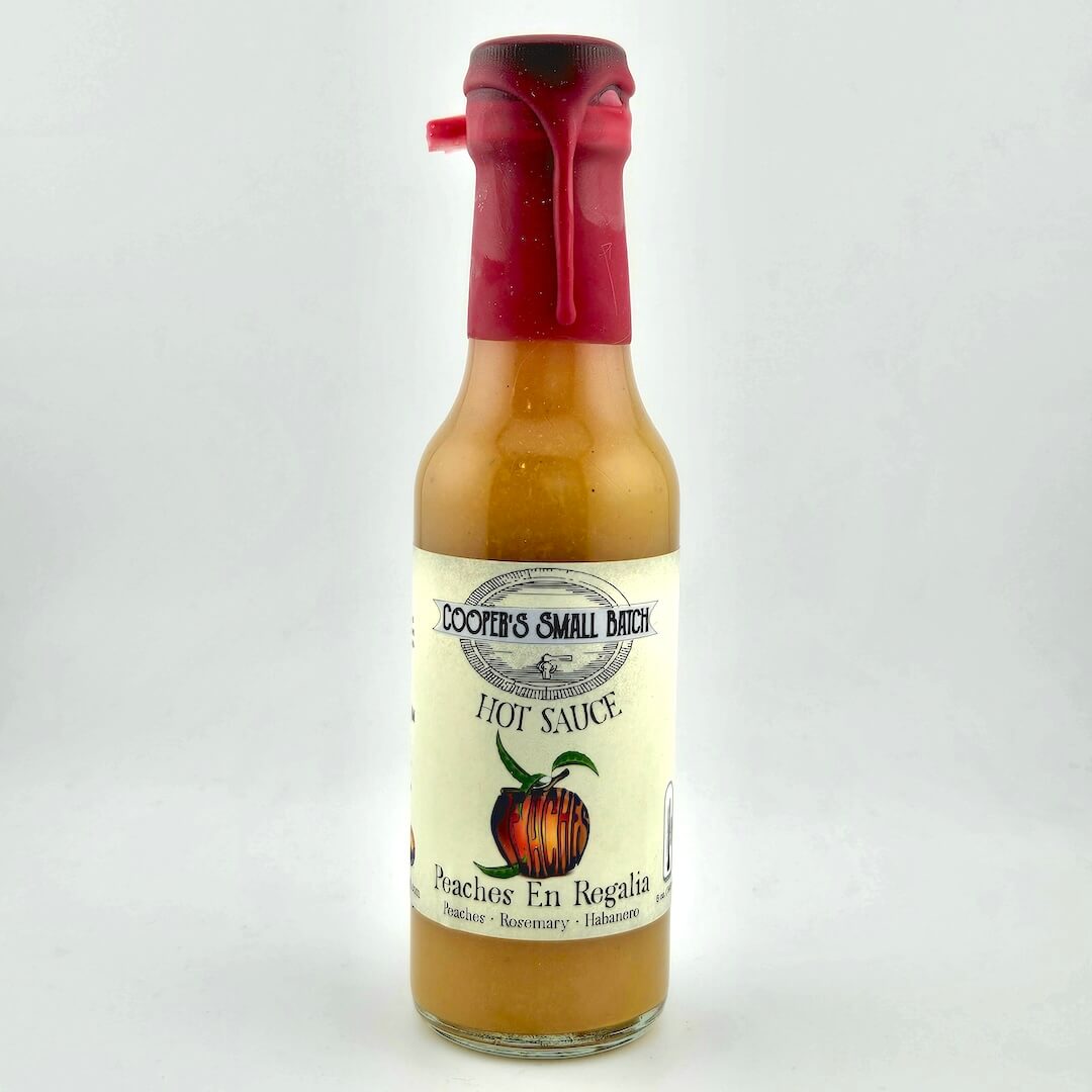 Bottle of Cooper's Small Batch Hot Sauce with a red cap on a white background