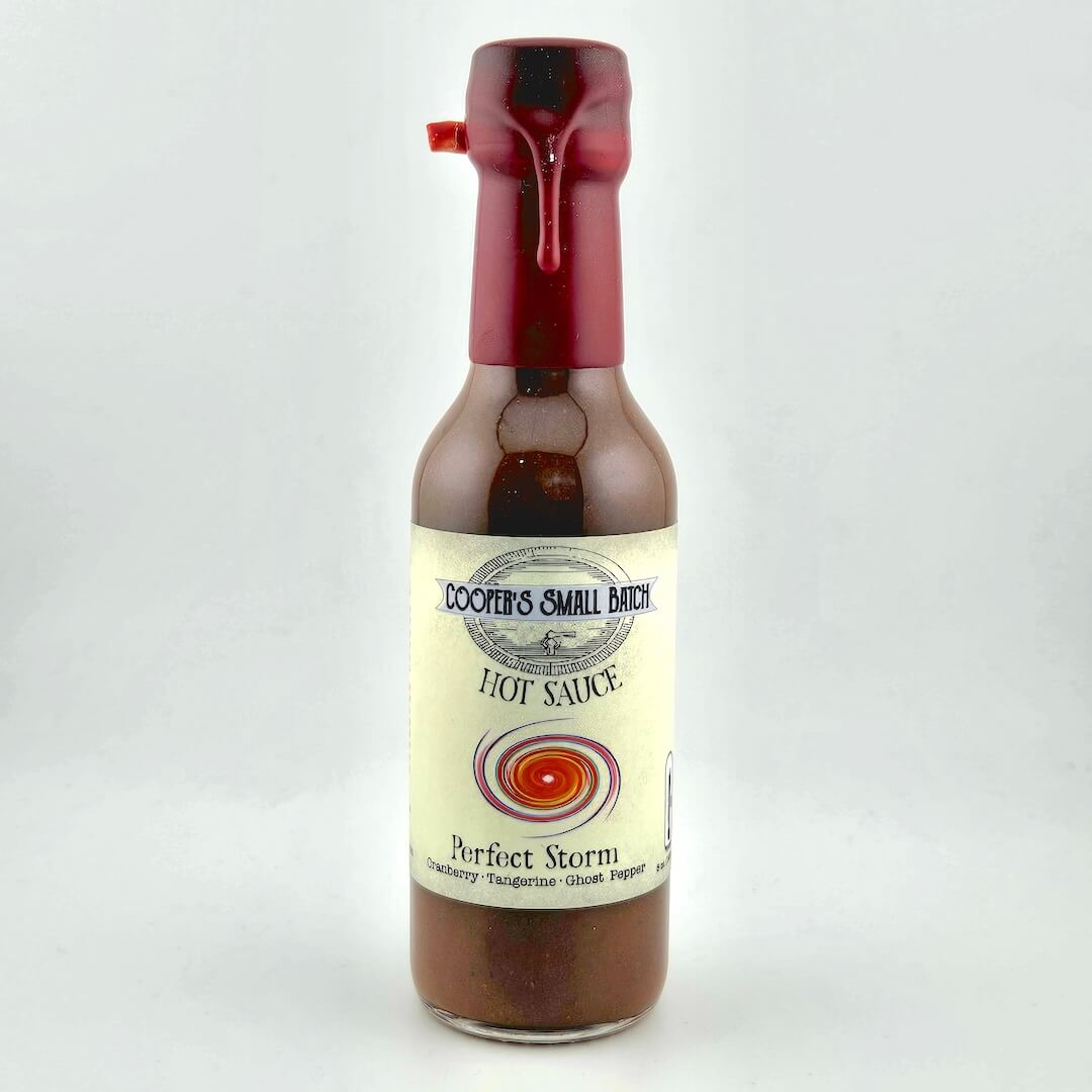 Bottle of hot sauce with a red cap on a white background