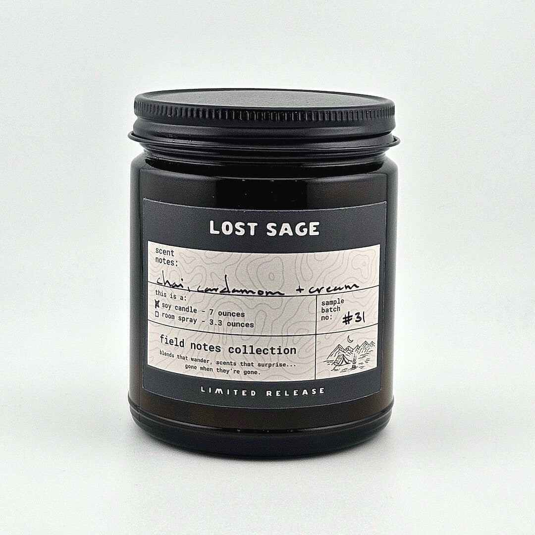 Black candle jar with 'Lost Sage' label on a white background