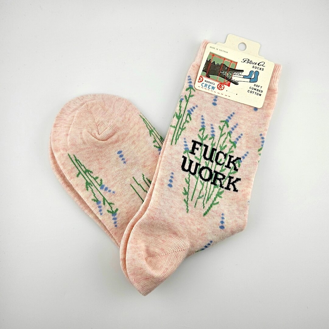 Pink socks with floral designs and 'F*ck Work' text on a light gray background
