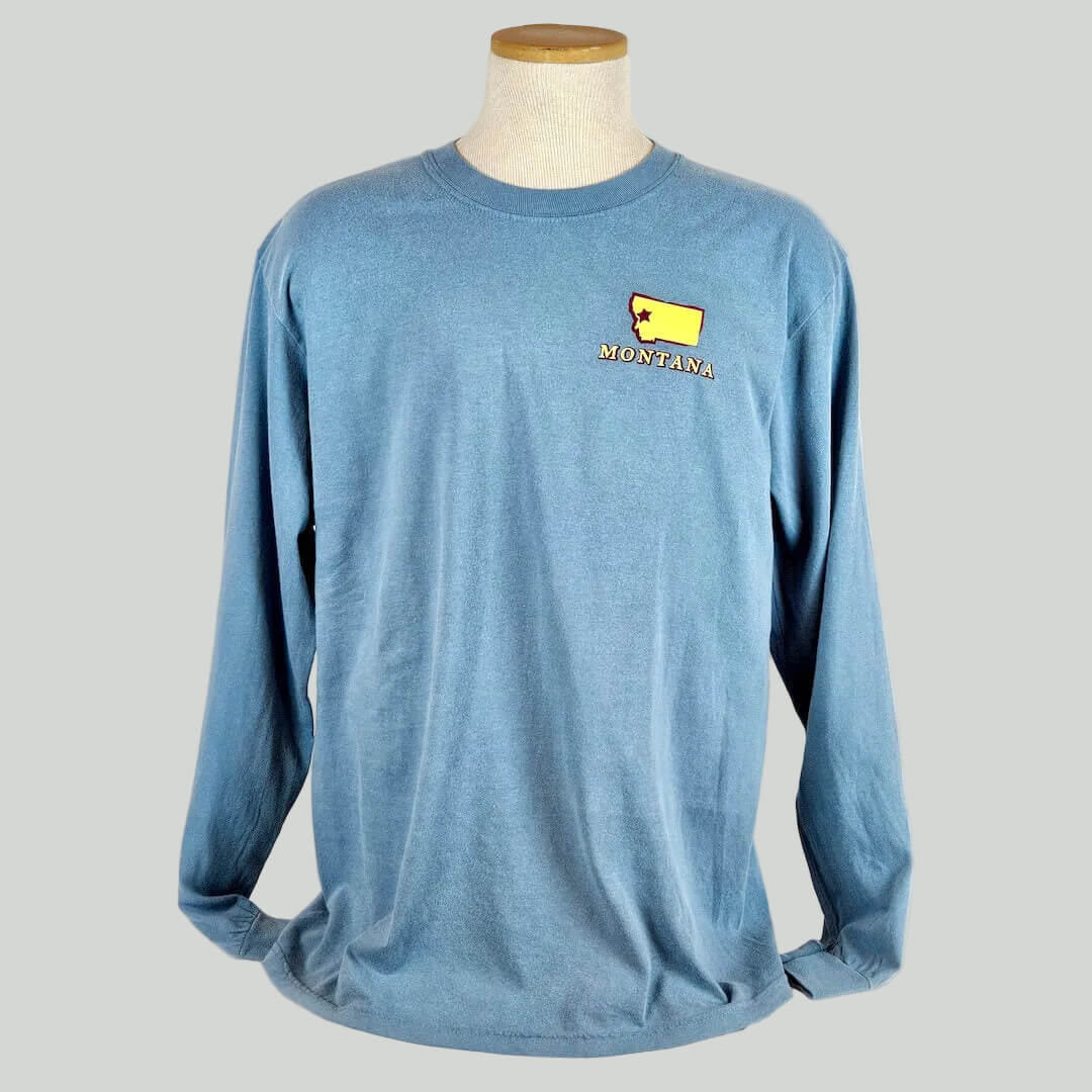 Blue long-sleeve shirt with a yellow and red 'Montana' logo on a mannequin against a white background