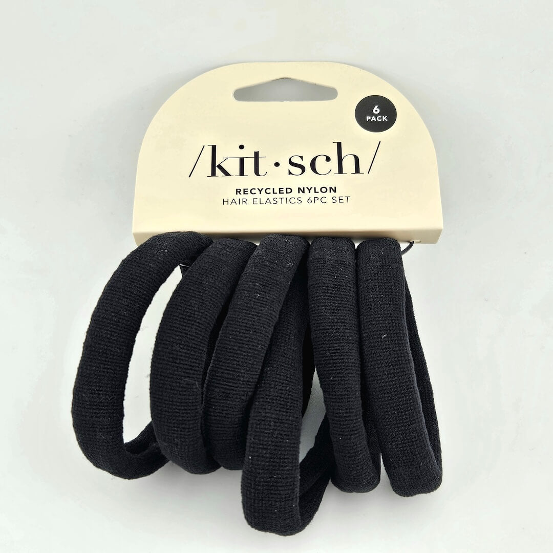 Black hair elastics on a 'kitsch' branded card against a white background