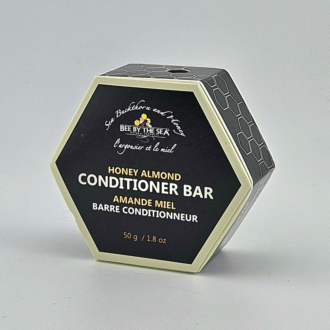 Hexagonal container of Honey Almond Conditioner Bar by Bee by the Sea on a gray background