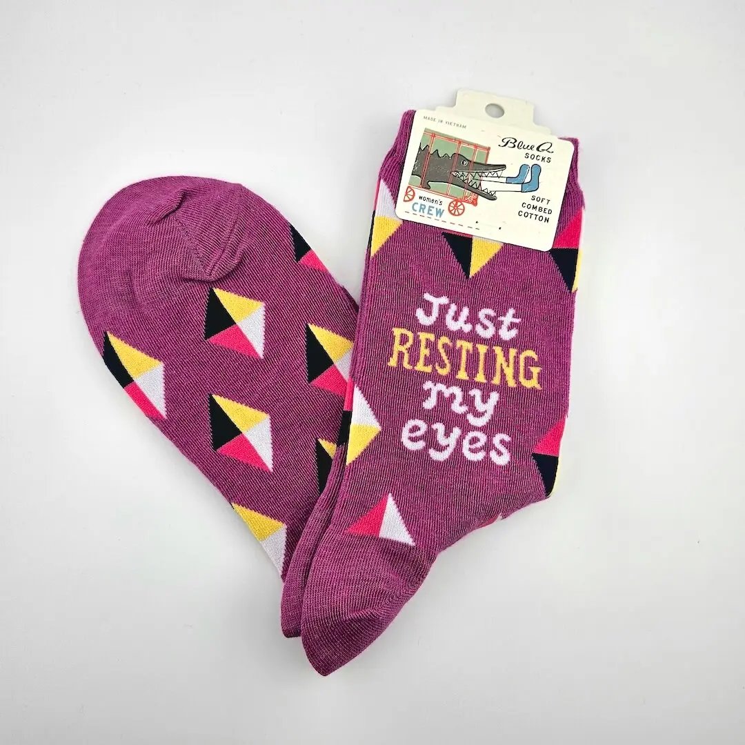 Pair of socks with geometric pattern and text 'Just Resting my Eyes' on a white background