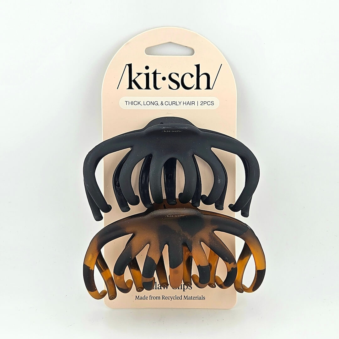 Two black and tortoiseshell hair clips on a 'kitsch' branded card against a white background.