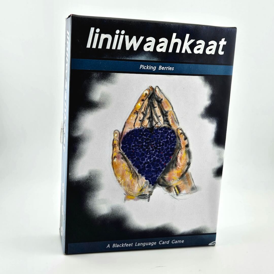 Card game box titled 'liniiwaahkaat' with a hand holding berries design on a white background