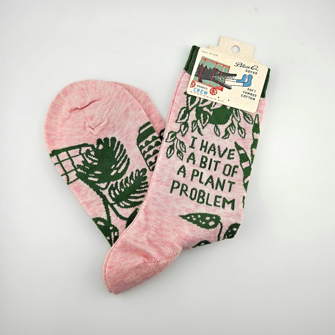 Pink socks with green leaf patterns and text on a white background