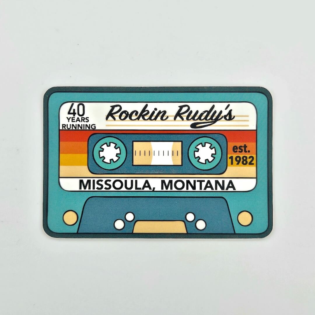 Sticker designed like a cassette tape with 'Rockin Rudy's' branding on a light gray background