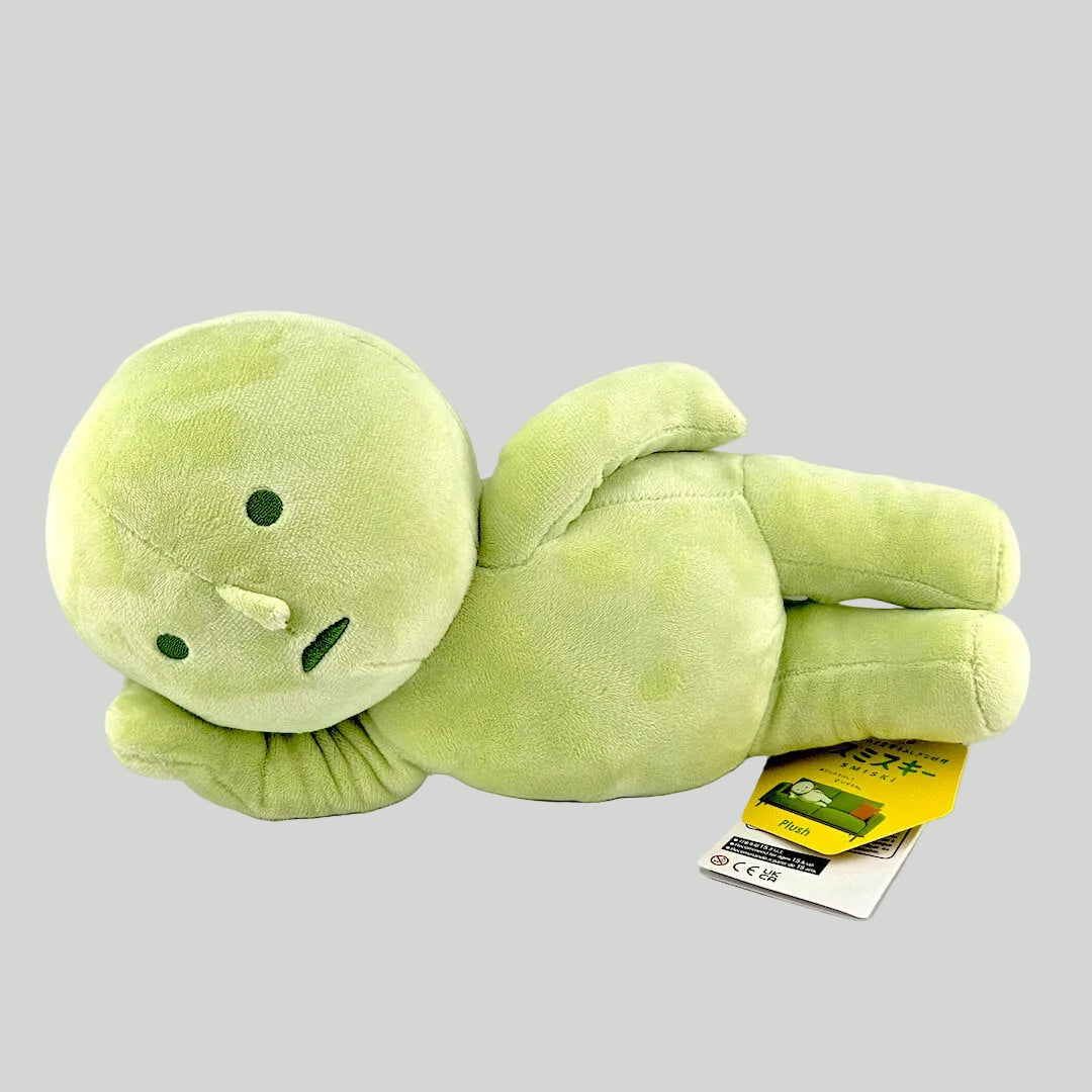 Green plush toy with a tag on a white background