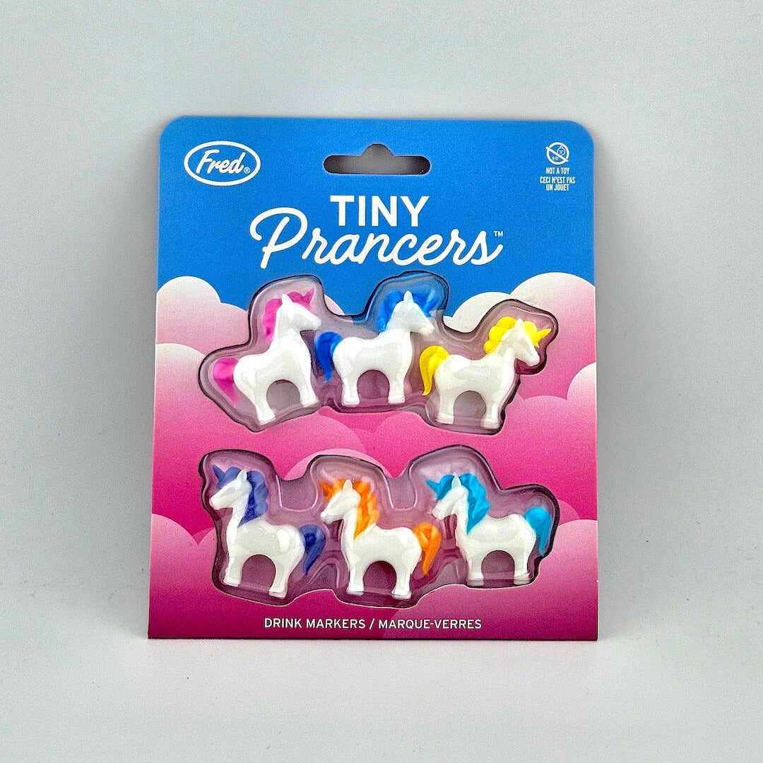 Brightly colored packaging for tiny unicorn drink charms against white background.