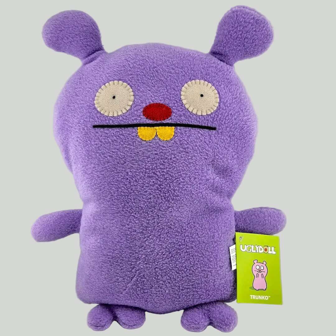 Purple plush toy with a smiling face on a white background