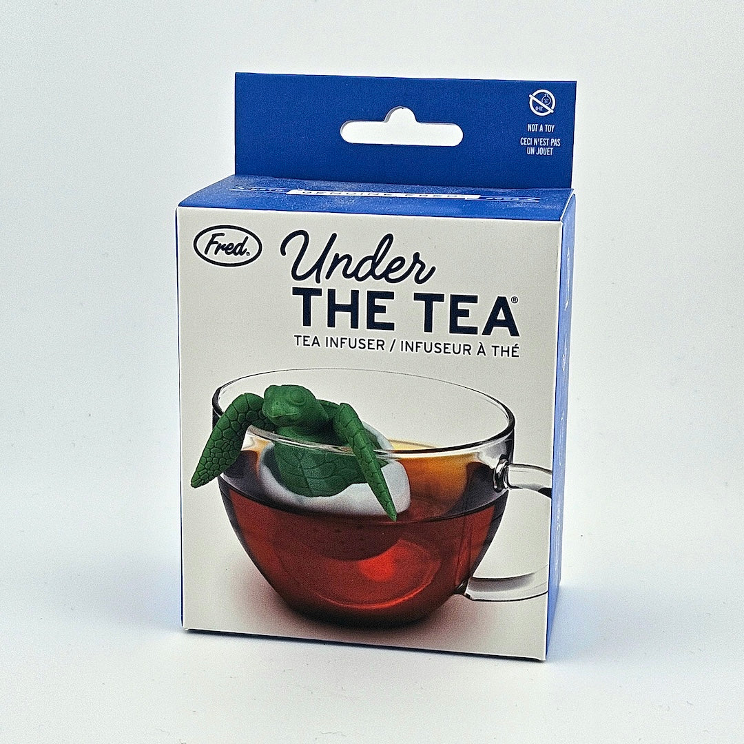 Packaging of turtle shaped Fred tea infuser with a clear glass cup on a white background