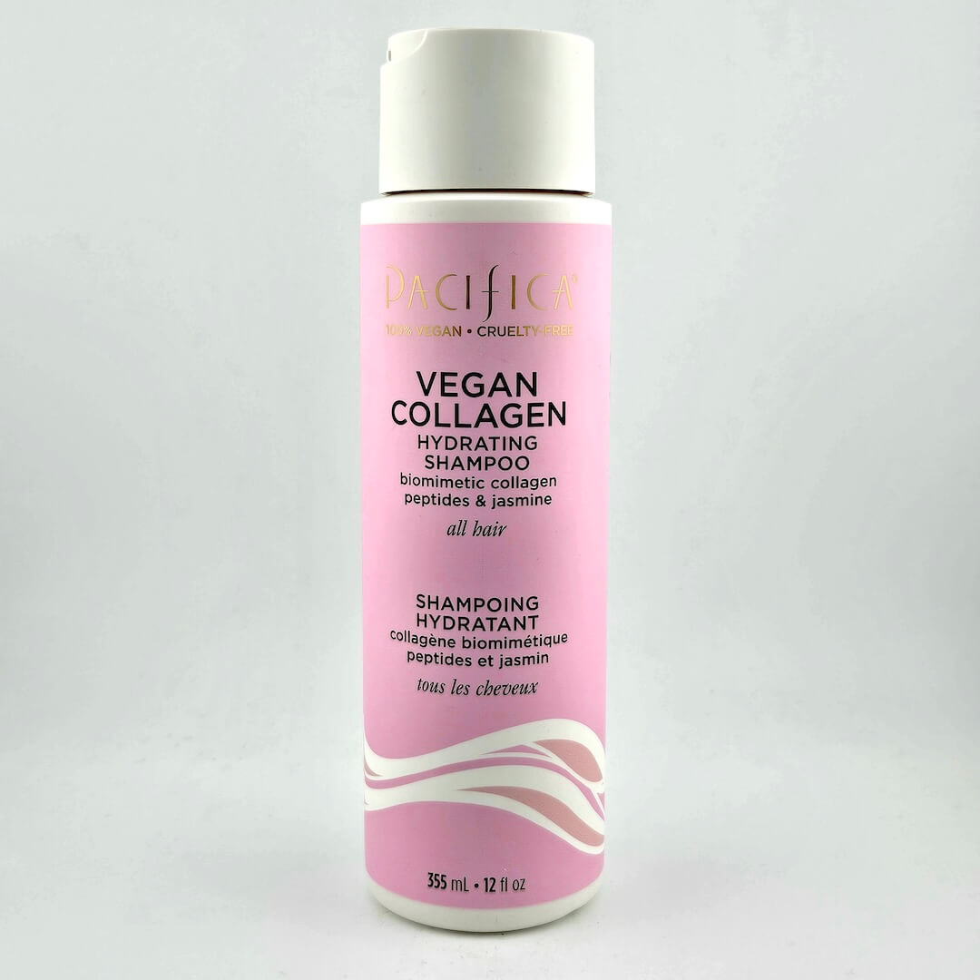Pink shampoo bottle with white cap on a light gray background