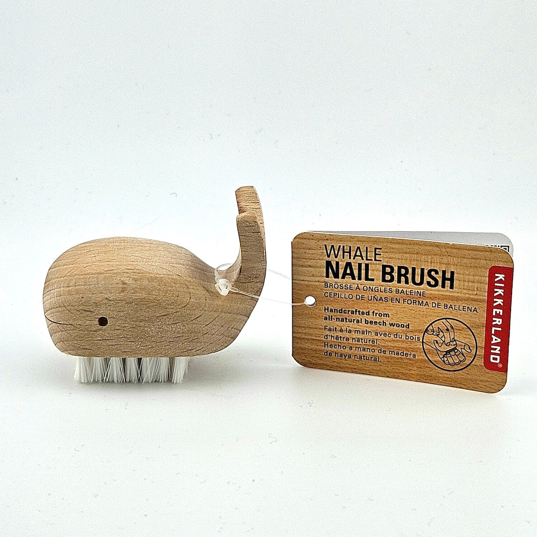 Wooden whale-shaped nail brush with packaging on a white background