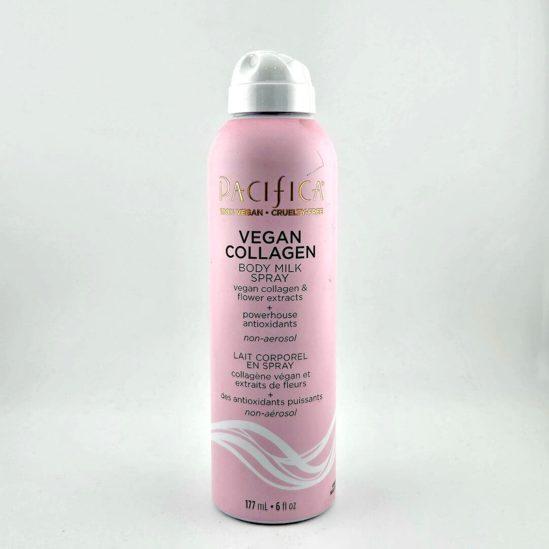 Pink body milk spray bottle with white cap on a light gray background