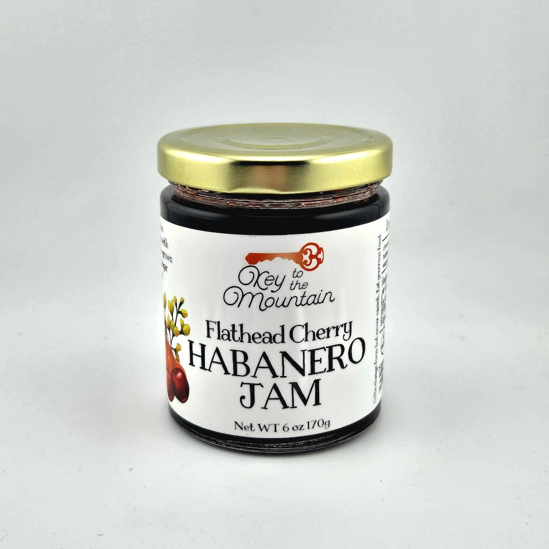 Jar of Flathead Cherry Habanero Jam with a gold lid on a white background