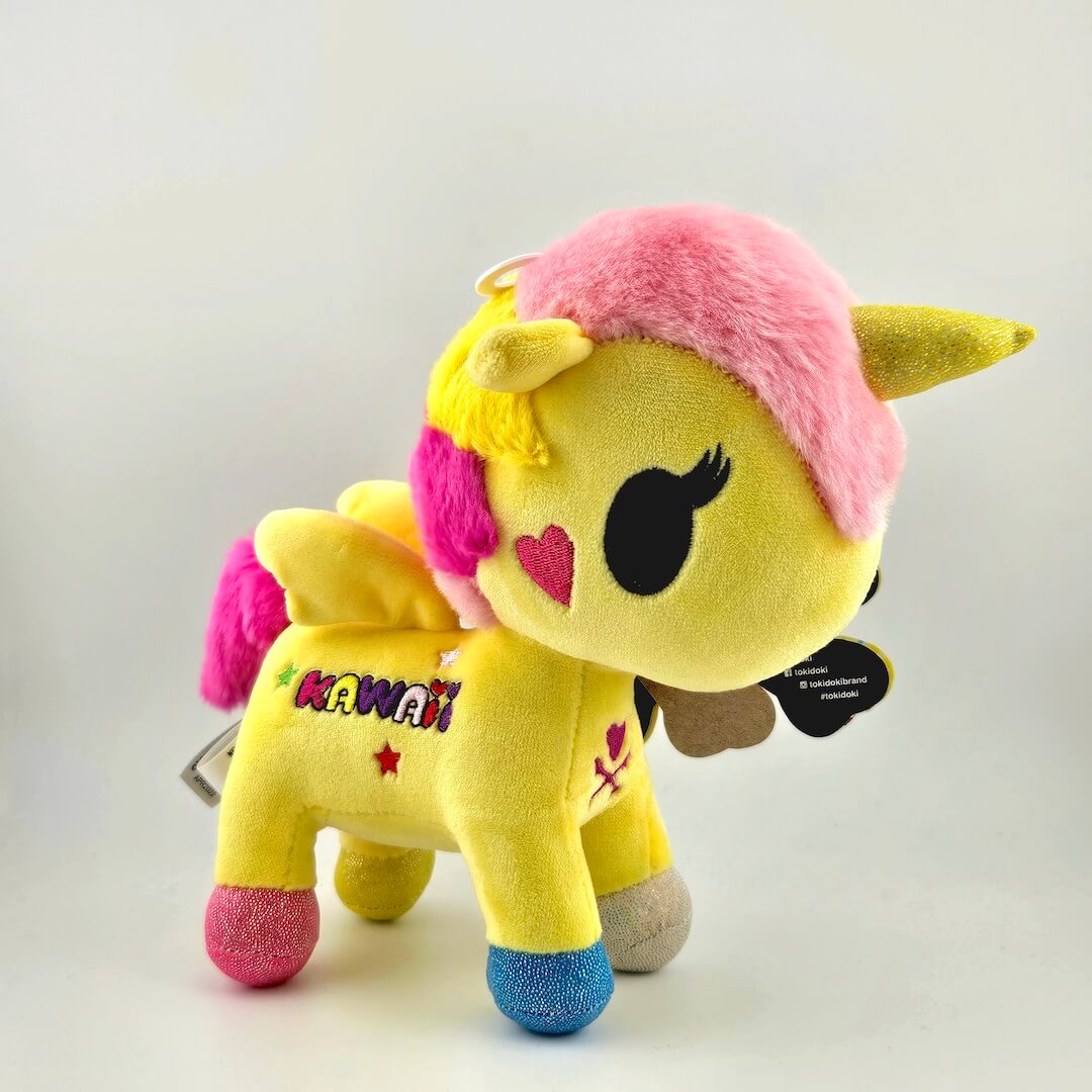 Yellow plush toy with pink hair and 'Kawaii' text on a light gray background