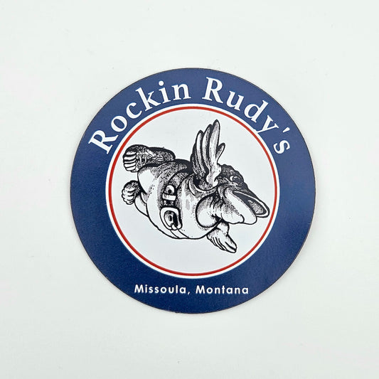 Round magnet with 'Rockin Rudy's' branding and a fish illustration on a white background