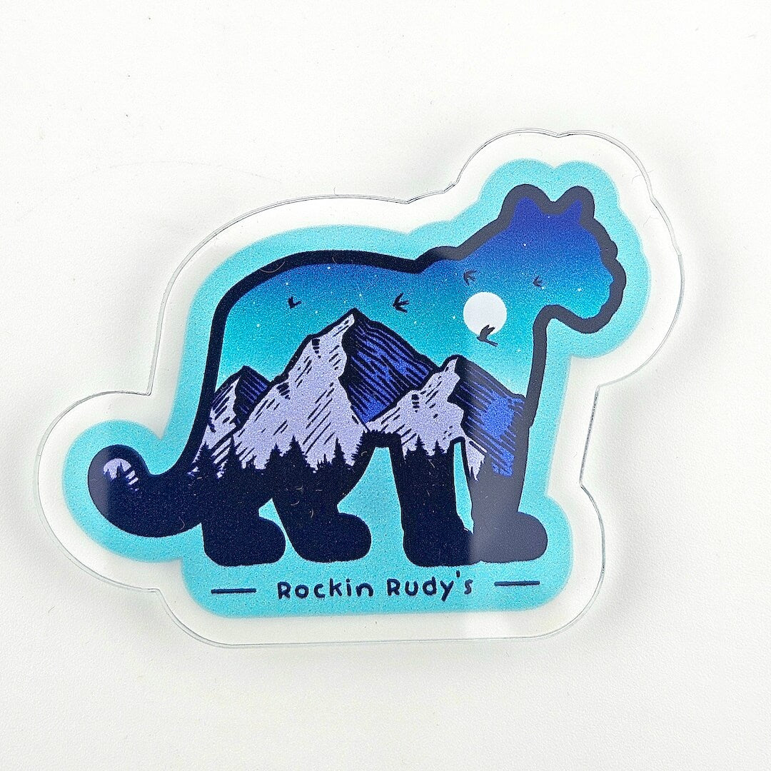 Magnet with a mountain lion design and mountain, featuring 'Rockin Rudy's' text, on a white background.