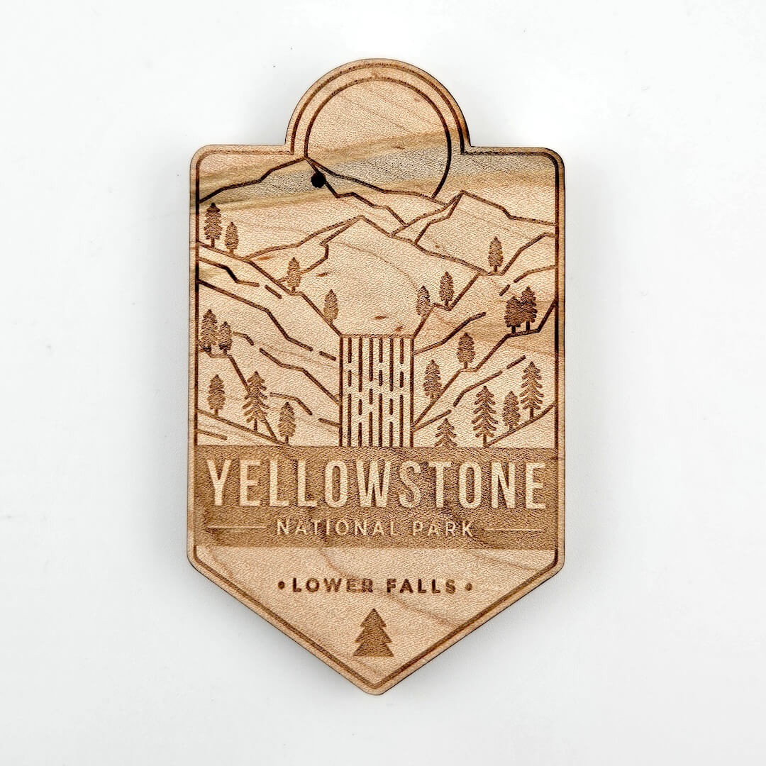 Wooden badge with Yellowstone National Park design on a white background