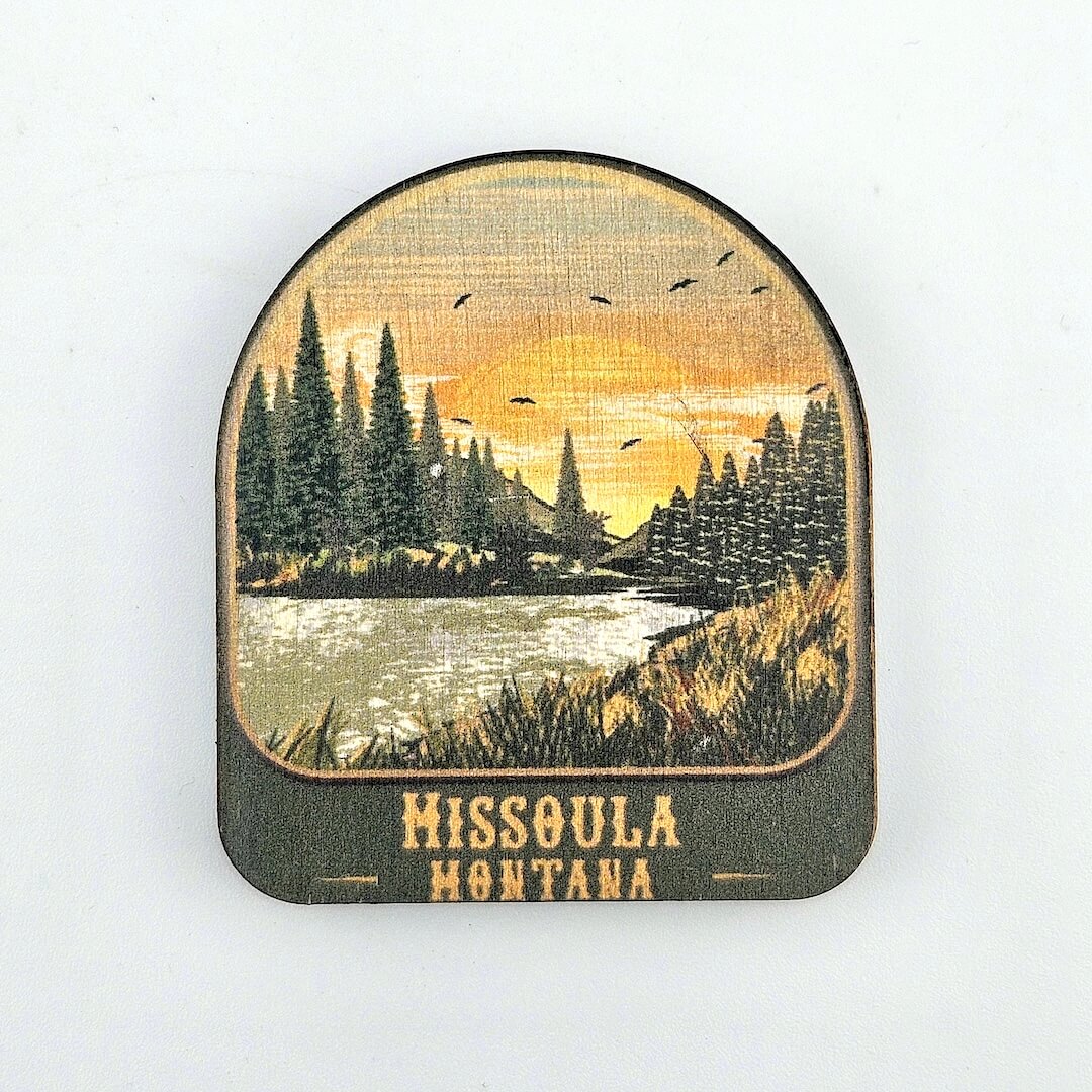 Wooden coaster with a scenic design of trees and sunset over water, featuring 'Missoula Montana'.