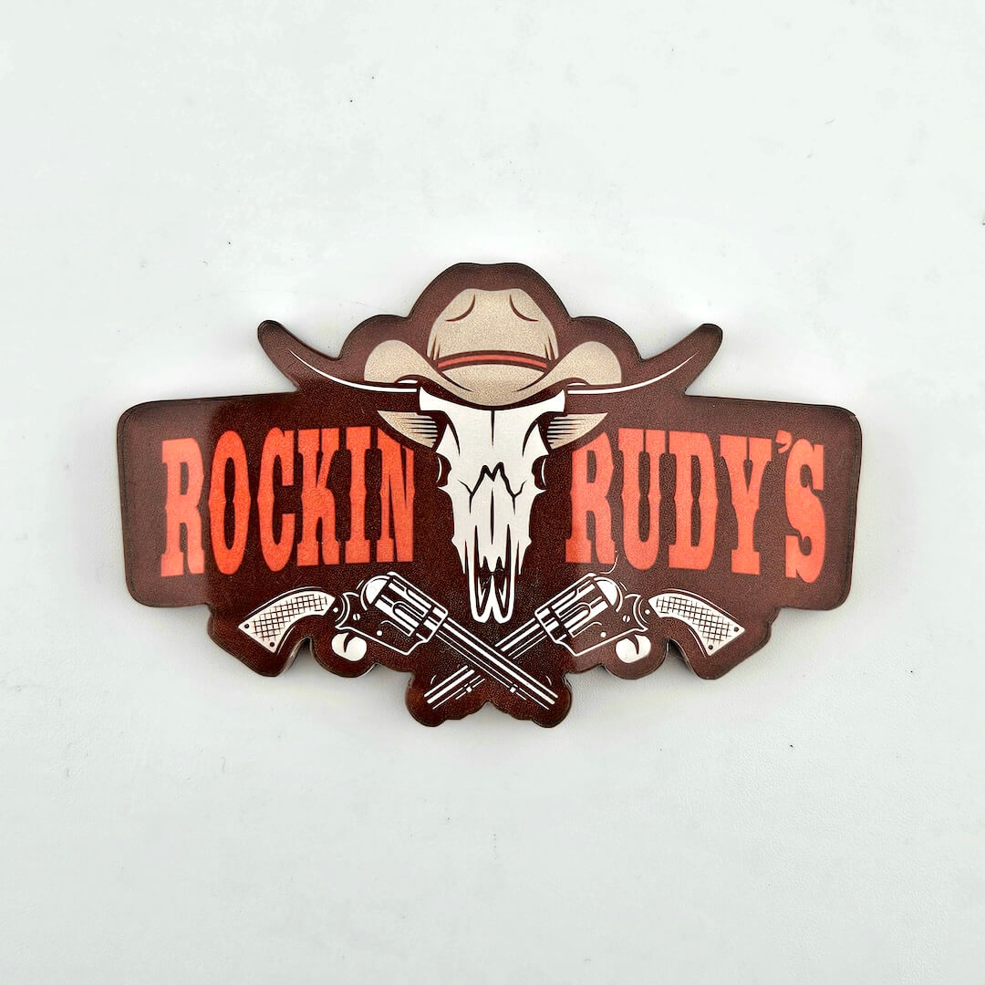 Logo of Rockin Rudy's with a skull and crossed revolvers on a white background
