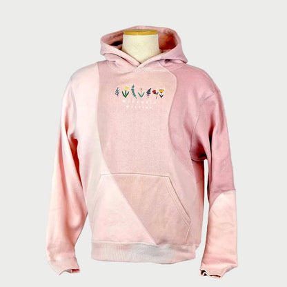 Pink hoodie with floral designs on a mannequin against a plain background