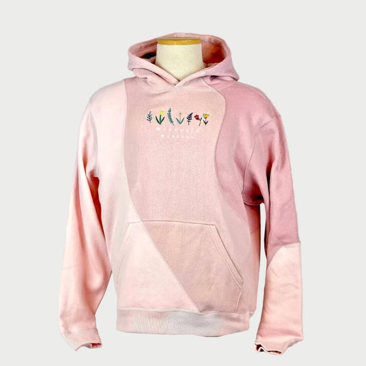 Pink hoodie with floral designs on a mannequin against a plain background
