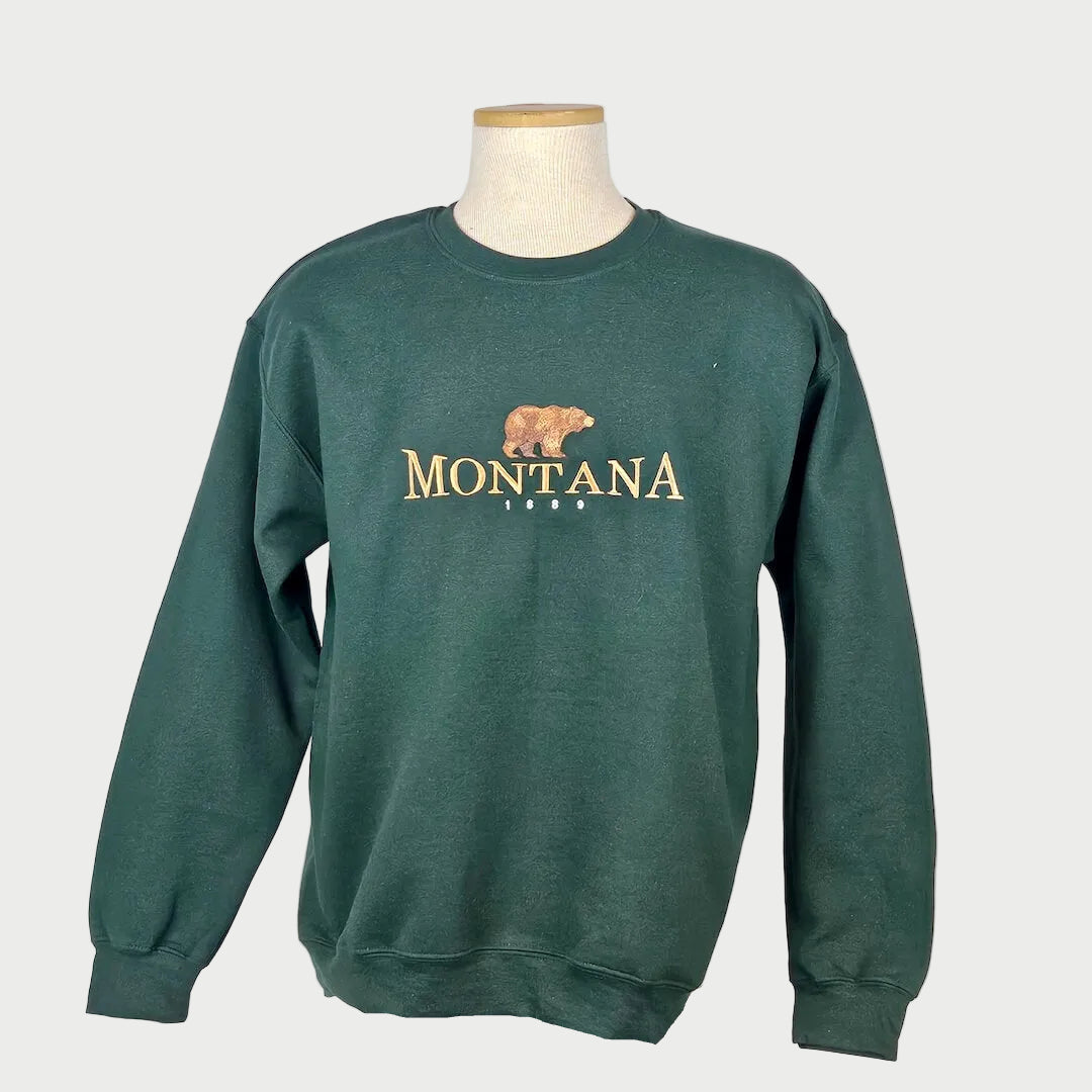Green sweatshirt with 'Montana' and a bear graphic on a mannequin against a white background
