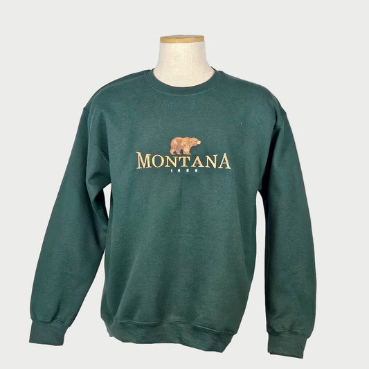 Green sweatshirt with 'Montana' and a bear graphic on a mannequin against a white background