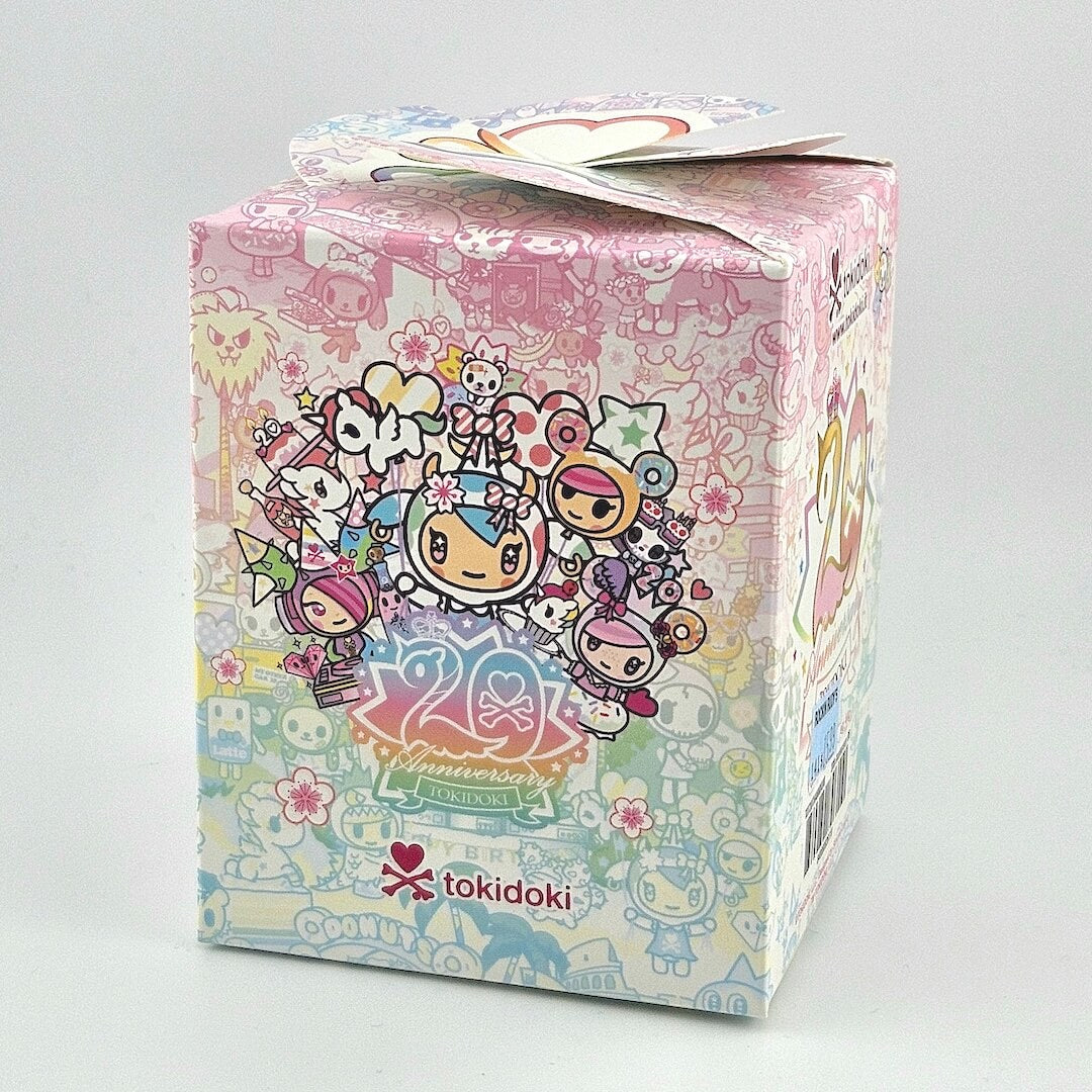 Brightly colored packaging for blind box unicorn figure against gray background. 