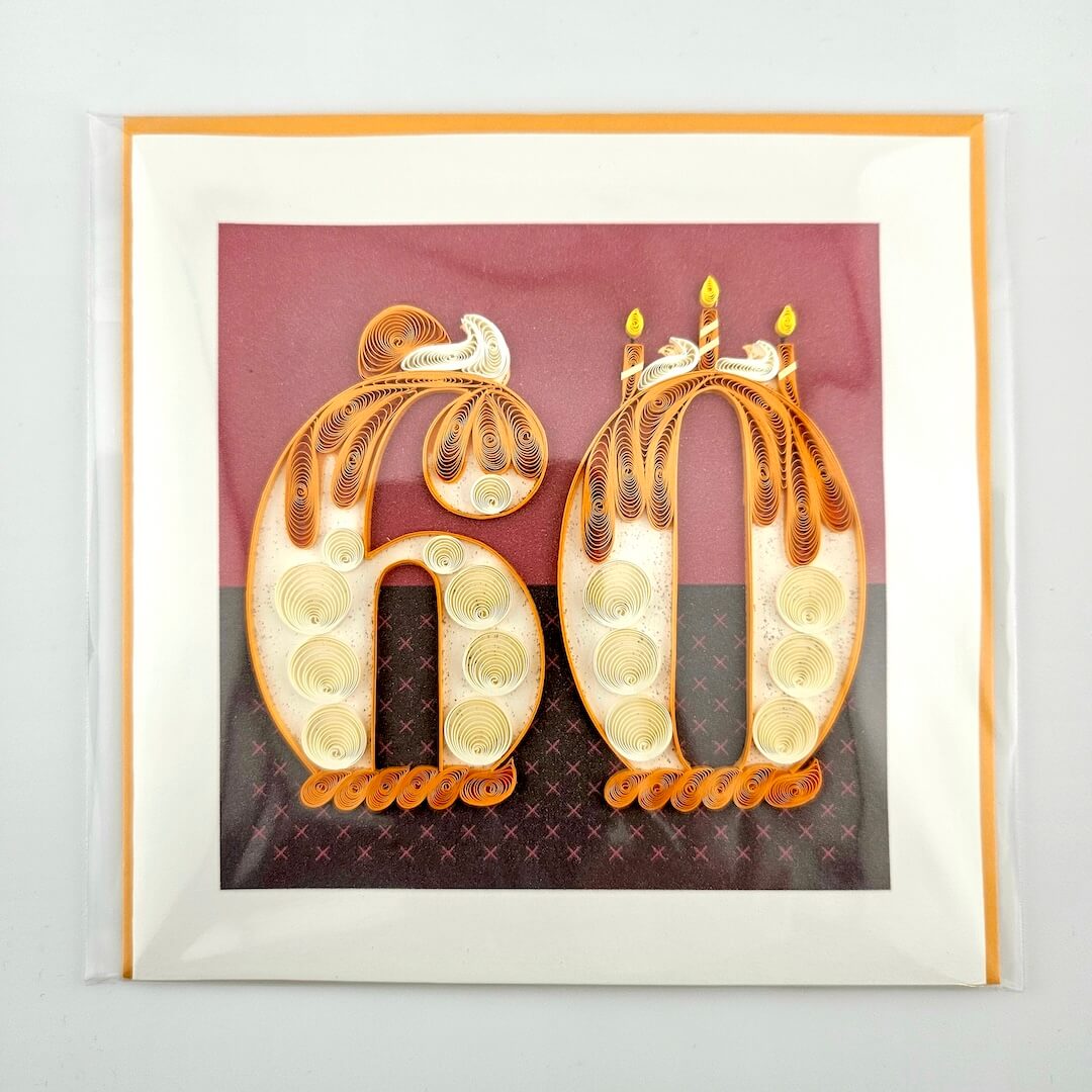 Framed artwork with decorative numbers '60' featuring candles on a maroon background.