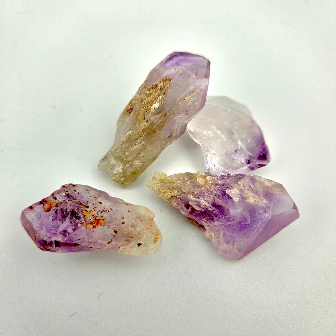 Four purple and gold crystal rocks on a white background