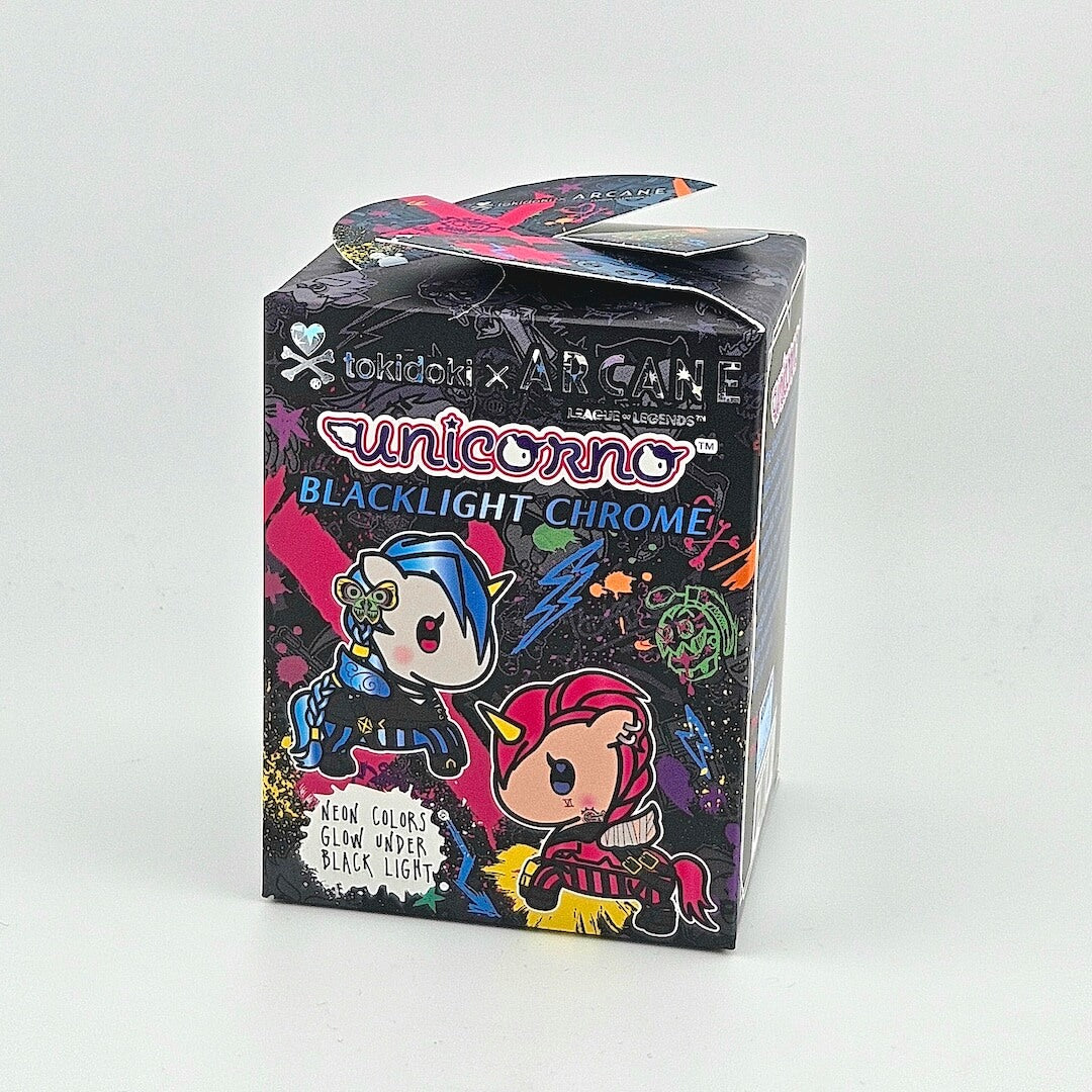 Brightly colored packaging for blind box unicorn figure against gray background. 