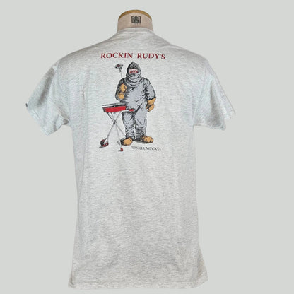 Heathered gray t-shirt with "ROCKIN RUDY'S" at top with man in hazmat suit grilling a record, city name at bottom. 