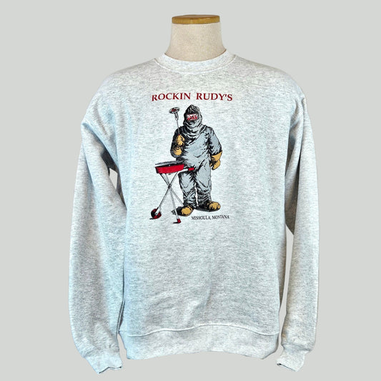 Gray sweatshirt with a graphic of a person in a welding suit, labeled 'Rockin Rudy's', on a mannequin against a white background.
