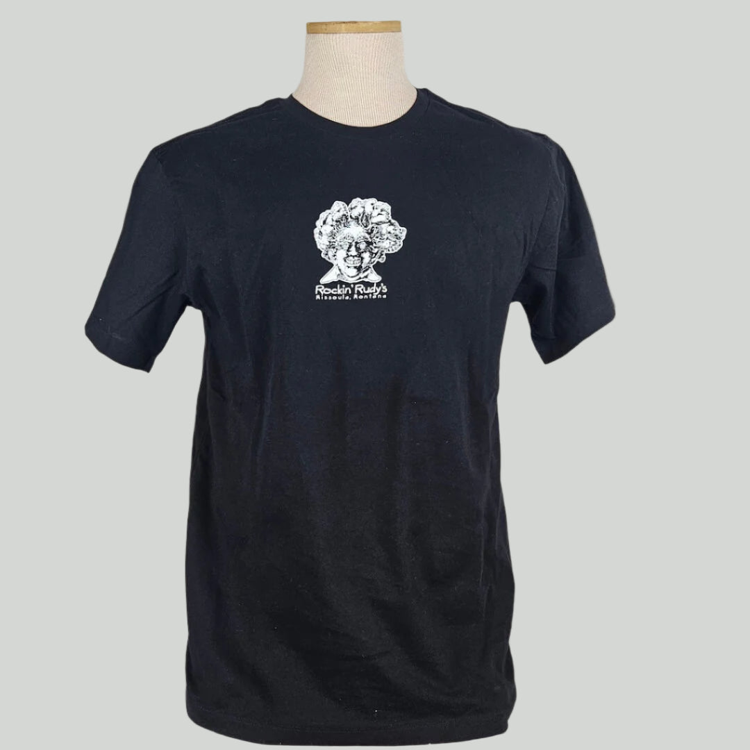Black shirt with smiling man’s head with trees for hair, "Rockin Rudy's, Missoula, Montana," printed below in center chest.